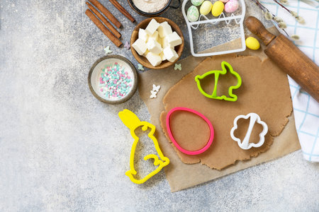 Easter baking ingredients background. Flour, eggs, milk, sugar, butter and kitchen utensils for baking on a stone table. view from above. copyspace.の写真素材
