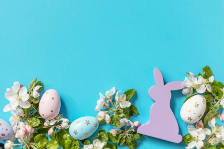 Easter composition with colorful eggs, wooden bunny and spring flowers on a blue background. Spring concept, flowers composition. greeting card. view from above. copyspace.の写真素材