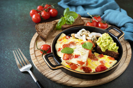 Omelette or omelet with sweet peppers and tomatoes, toasts bread with avocado and salted seafood. Healthy keto diet low carb breakfast. copyspace.の写真素材