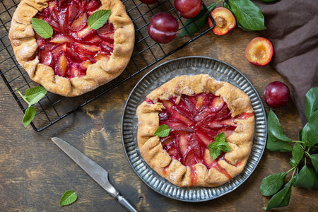 Vegan vegetarian dessert, plums galette with almonds. Healthy homemade wholegrain fruit pie, sweet crostata on a rustic table. view from above.の写真素材