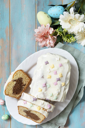 Cupcake with Easter Bunny and colorful eggs on a wooden blue tabletop. View from above. Copy space....