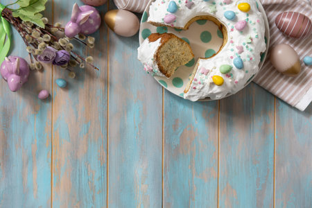 Glazed easter lemon cake decorated with confectionery and mini chocolate eggs candy on a wooden table. Happy Easter holidays, tasty dessert. View from above. Copy space.の写真素材
