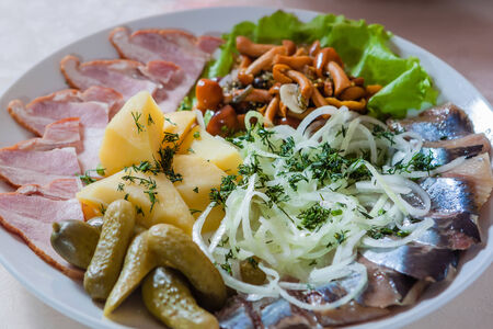 Assorted variety of snacks: potato, fish, cucumbersの写真素材