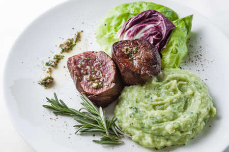 Steak with lettuce, rosemary and mashed potatoesの写真素材