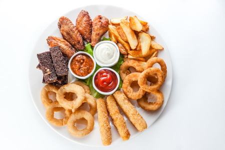 Assorted hot snacks. roasted cheese, croutons, onion rings with ketchupの写真素材