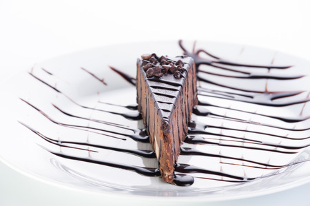 Dessert chocolate cake with topping and nuts on a white backgroundの写真素材