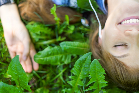 Woman listening to music with headphones at the park.の写真素材