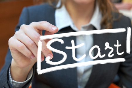 Woman holding floating render startup presentation with note. Writing finger in the air inscription "Start"の写真素材
