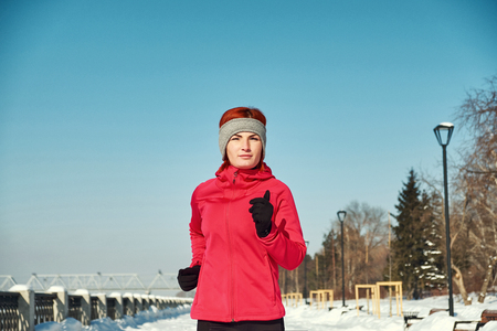 Running athlete woman sprinting during winter training outside in cold snow weather. Close up showing speed and movement.の写真素材