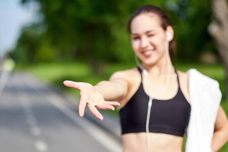 Welcome to sport and Run. Attractive fit Asian woman welcomes you to running track with a handshake. Gives a helping hand.の写真素材