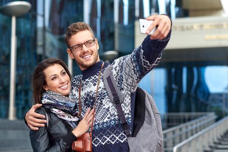Happy couple of tourists taking selfie in old city