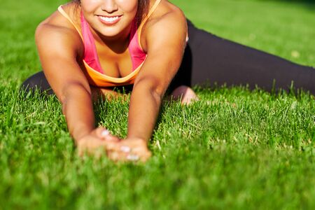 Yoga. Young woman practicing yoga or dancing or stretching in nature at park. Health lifestyle concept.の写真素材