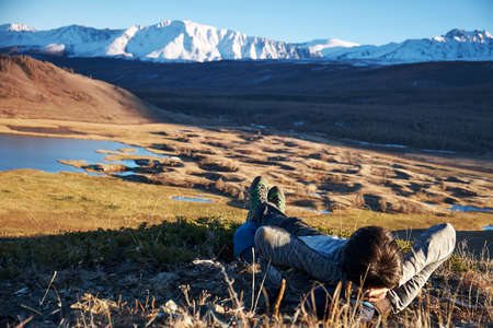 Hikers lie down taking resting after long walk at top of mountain.の写真素材