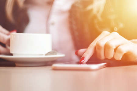 Woman hands with smart phone, headphones and cup of tea. For Graphic display montageの写真素材