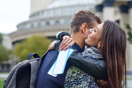 happy cheerful couple hugging and showing flying tickets. man making a surprise to a woman - giving...