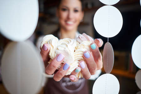 Woman baker or pastry chef with marshmallow dessert in bakeryの写真素材