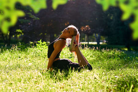 Yoga. Young woman practicing yoga or dancing or stretching in nature at park. Health lifestyle...