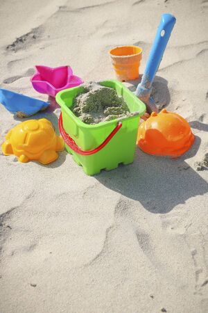 Colored children's toys on the sandy beachの写真素材