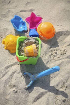 Colored children's toys on the sandy beachの写真素材