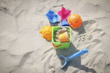 Colored children's toys on the sandy beachの写真素材