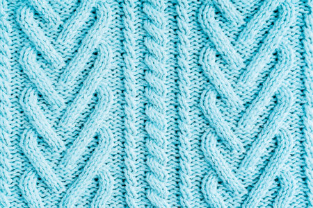 Background of top view of pastel color blue woven cozy warm casual sweater cardigan texture handmade...