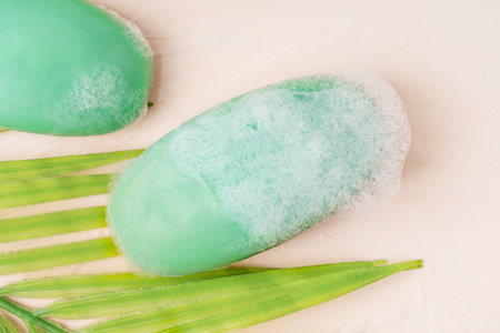 Top view of antibacterial hygienic natural craft soap bars of green color wet soapy and covered with...