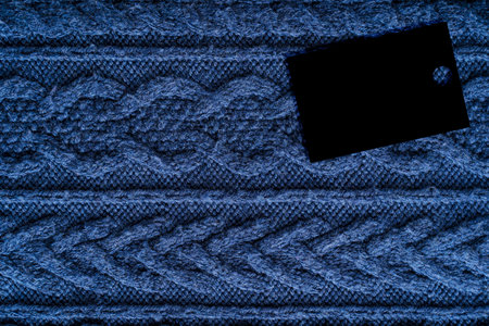 Background of top view of textile surface of woven cozy warm knitwear of dark blue color with...