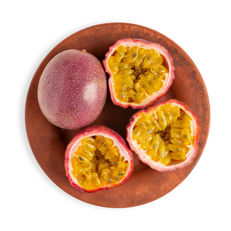 Top view of ripe raw whole and cut in halves passion fruit or maracuya with edible yellow juicy...