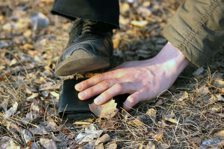 Do not steal (Male foot attacks a hand reaching for another's wallet)の写真素材
