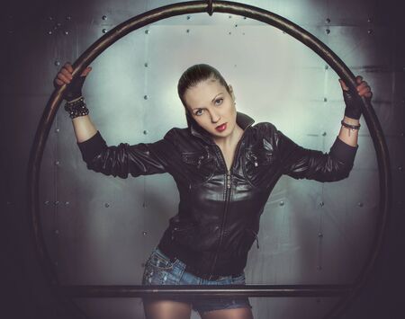sexy girl in leather jacket holding round constructionの写真素材