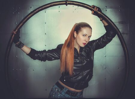 sexy girl in leather jacket holding round constructionの写真素材