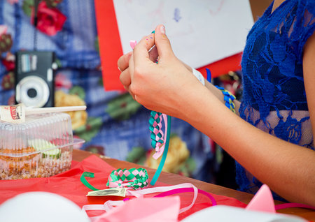 ZAPOROZHYE, UKRAINE - SEPTEMBER 5, 2015. Bracelets braiding workshop during family festival organized by Charity Fund Childs Smile for citizens and Donetsk refugees, financed by USAIDのeditorial素材