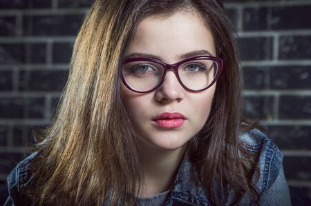 Portrait of beautiful brunette teen girl, wearing glassesの写真素材