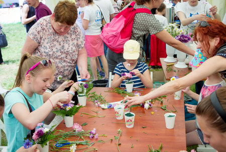 Zaporizhia / Ukraine- May 28, 2017: Charity Family Festival: teen girl participating at floristic workshop, learning to arrange fresh flowers in beautiful bouquetsのeditorial素材