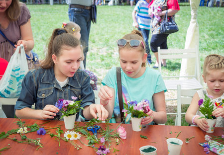 Zaporizhia / Ukraine- May 28, 2017: Charity Family Festival: teen girls participating at floristic workshop, learning to arrange fresh flowers in beautiful bouquetsのeditorial素材