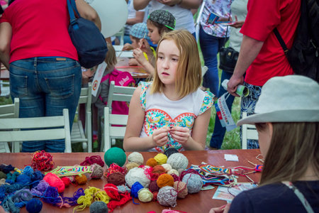 Zaporizhia / Ukraine- May 28, 2017: Charity Family Festival- girls learning to make colorful table...