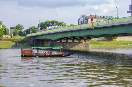 Krakow / Poland - August 14, 2017: Vistula River, tourists enjoy, traveling by water on a small cruise boat on a sunny summer dayのeditorial素材
