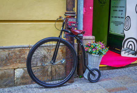 Krakow / Poland - August 15, 2017: Retro style bicycle and basket with colorful artificial flowers decorating shop entry, Florianska street, old townのeditorial素材
