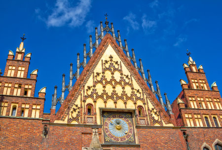 Wroclaw / Poland - August 17, 2017: Market Square - part view of beautiful gothic old Town Hall with ornaments and clock over blue skyのeditorial素材