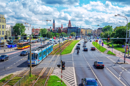 Wroclaw / Poland - August 17, 2017: view of city traffic - tram, bus, taxi, motorcycle, trucks and cars moving on the road with buildings on background and cloudy sky.のeditorial素材