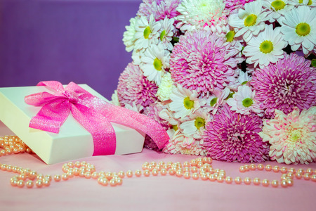 Beautiful white and pink aster and chrysanthemums bouquet - colorful fresh flowers arrangement, white present box with pink ribbon and pearl beads.の写真素材