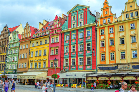Wroclaw / Poland - August 19, 2017: cityscape of the old town Market Square with colorful ornate historical buildings, outdoors restaurants with sunshades, citizens and tourists walking aroundのeditorial素材
