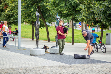 Wroclaw / Poland - August 19, 2017: young man - street musician playing bagpipe in a park, summertime city life.のeditorial素材