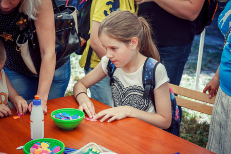 Zaporizhia / Ukraine- June 2, 2018: girl participating in making colorful paper flowers workshop on city family charity festivalのeditorial素材