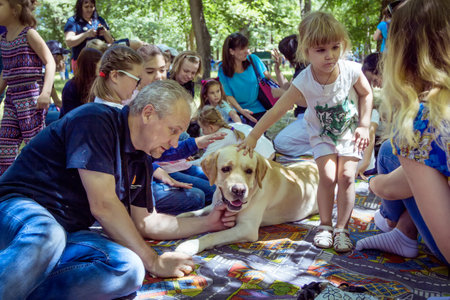 Zaporizhia / Ukraine- June 2, 2018: Children and their specially trained labrador at the city parkのeditorial素材