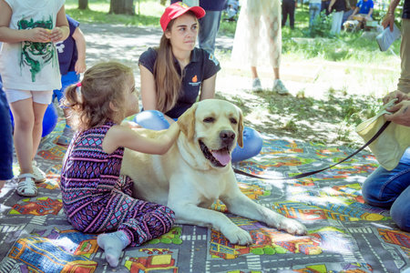 Zaporizhia / Ukraine- June 2, 2018: Children and their specially trained labrador at the city parkのeditorial素材