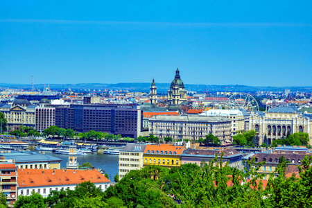 Budapest/Hungary- May 6, 2018: spring aerial view of the city from Gellert hill with colorful old historical buildings, Danube river. Green trees, hills on the horizon and blue sky.のeditorial素材