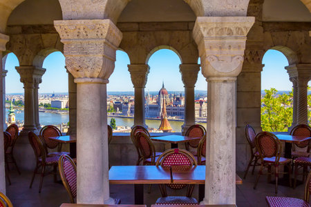 Budapest/Hungary- May 7, 2018: outdoors restaurant â tables and chairs -  with view to Danube river and spring cityscape â beautiful historic Parliament buildingのeditorial素材