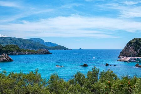 Beautiful landscape with sea, mountains and cliff in a water, green trees and blue sky. Corfu...