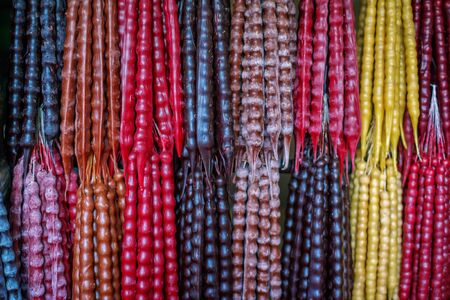 Colorful traditional homemade Georgian sweet dessert- churchkhela, made of fruit juice and nuts, hanging at outdoor market for sale.の写真素材